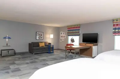 a hotel room with a bed and a tv and a couch at Hampton Inn & Suites Xenia Dayton in Xenia