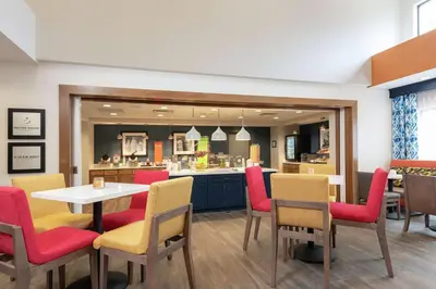a restaurant with a table and chairs and a counter at Hampton Inn & Suites Xenia Dayton in Xenia