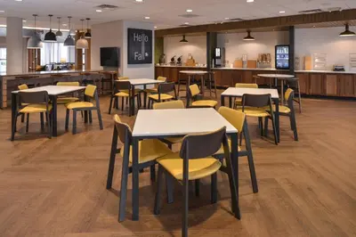 a dining room with tables and yellow chairs at Fairfield Inn & Suites by Marriott Columbus Grove City in Grove City
