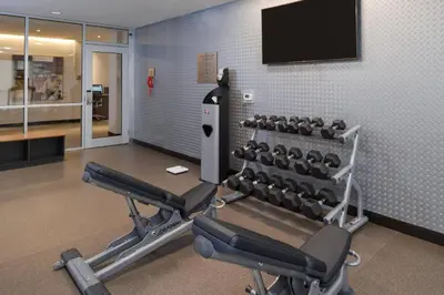 a gym with two rows of exercise equipment and a flat screen tv at Fairfield Inn & Suites by Marriott Columbus Grove City in Grove City
