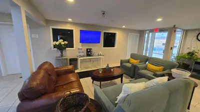 a living room with two couches and a tv at Copley Inn & Suites By OYO Akron OH in Akron