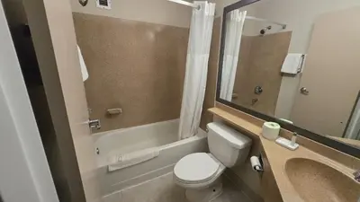 a small bathroom with a toilet and a sink at Copley Inn & Suites By OYO Akron OH in Akron