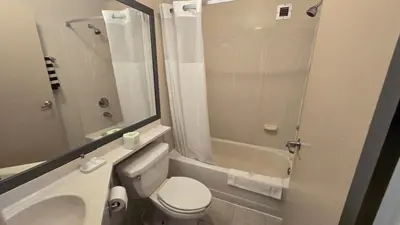 a bathroom with a toilet and a sink and a shower at Copley Inn & Suites By OYO Akron OH in Akron