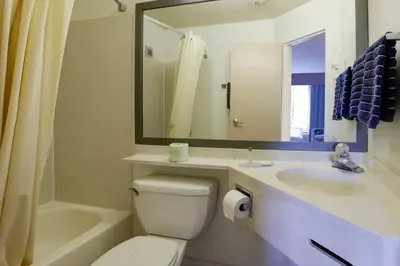 a bathroom with a toilet and a sink and a mirror at Copley Inn & Suites By OYO Akron OH in Akron
