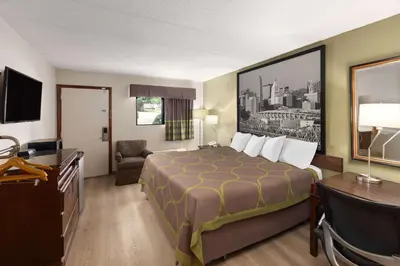 a hotel room with a bed and a desk at Super 8 by Wyndham Fort Mitchell Cincinnati Area in Fort Mitchell