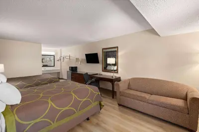 a hotel room with a bed and a couch at Super 8 by Wyndham Fort Mitchell Cincinnati Area in Fort Mitchell