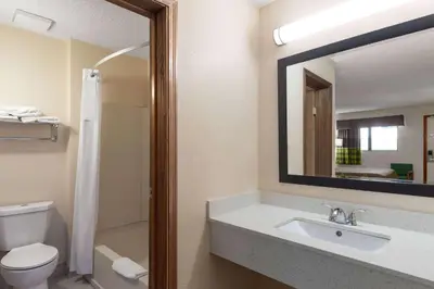 a bathroom with a sink and a toilet and a mirror at Super 8 by Wyndham Fort Mitchell Cincinnati Area in Fort Mitchell