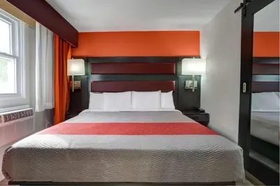 a hotel room with a bed with an orange headboard at Motel 6 Bellville, OH in Bellville