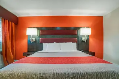 a bed in a room with an orange wall at Motel 6 Bellville, OH in Bellville