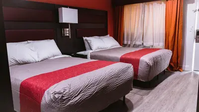 two beds in a hotel room with red walls at Motel 6 Bellville, OH in Bellville
