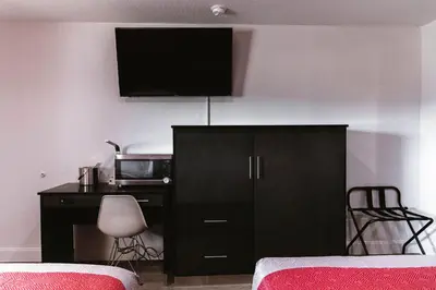 a bedroom with a black cabinet with a tv on the wall at Motel 6 Bellville, OH in Bellville