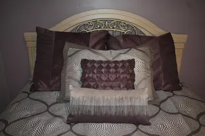 a bed with brown and white pillows on it at Cozy 2 Bedroom House in Adrian