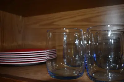 three empty glasses sitting on a wooden table at Cozy 2 Bedroom House in Adrian