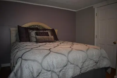 a bedroom with a bed with a white comforter at Cozy 2 Bedroom House in Adrian