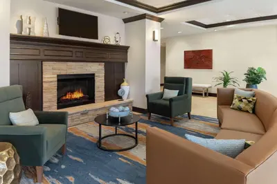 a living room with couches and a fireplace at Homewood Suites Fort Wayne in Fort Wayne