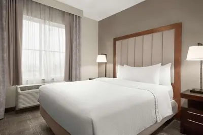 a bedroom with a large white bed and a window at Homewood Suites Fort Wayne in Fort Wayne