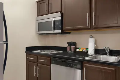 a small kitchen with a sink and a microwave at Homewood Suites Fort Wayne in Fort Wayne