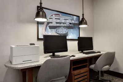 a desk with two monitors and a printer and two chairs at Homewood Suites Fort Wayne in Fort Wayne