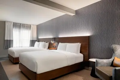 a hotel room with two beds and a chair at Four Points by Sheraton Columbus-Polaris in Columbus
