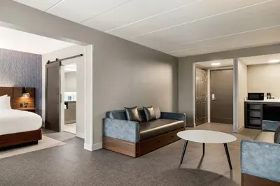 a hotel room with a bed and a couch and a table at Four Points by Sheraton Columbus-Polaris in Columbus