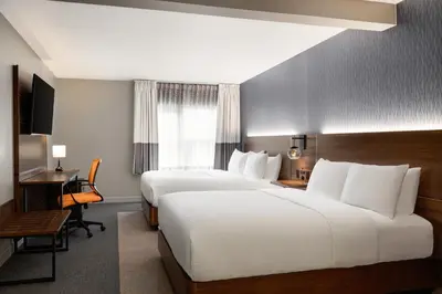 a hotel room with two beds and a desk at Four Points by Sheraton Columbus-Polaris in Columbus