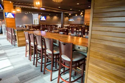 a bar in a restaurant with wooden tables and chairs at Hope Hotel and Richard C. Holbrooke Conference Center in Fairborn