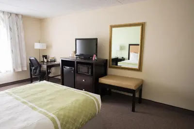 a hotel room with a bed and a mirror at Hope Hotel and Richard C. Holbrooke Conference Center in Fairborn
