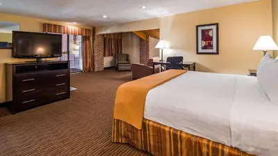 a hotel room with a large bed and a flat screen tv at Best Western Muncie in Muncie
