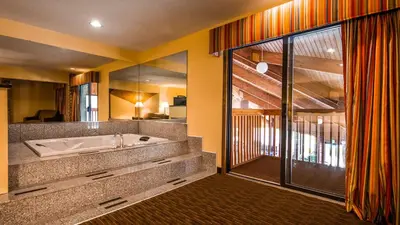 a bathroom with a tub and a large mirror at Best Western Muncie in Muncie