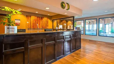 a bar in a restaurant with wooden floors at Best Western Muncie in Muncie