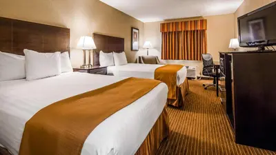 a hotel room with two beds and a flat screen tv at Best Western Muncie in Muncie