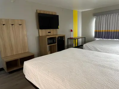 a hotel room with two beds and a flat screen tv at Super 8 by Wyndham Richfield Cleveland in Richfield