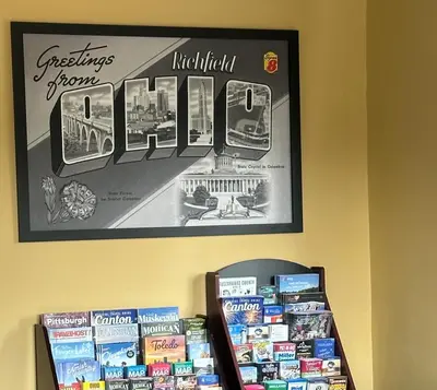 a sign hanging on a wall above a shelf of books at Super 8 by Wyndham Richfield Cleveland in Richfield