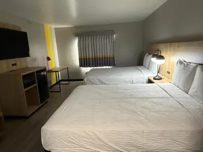 a hotel room with two beds and a flat screen tv at Super 8 by Wyndham Richfield Cleveland in Richfield