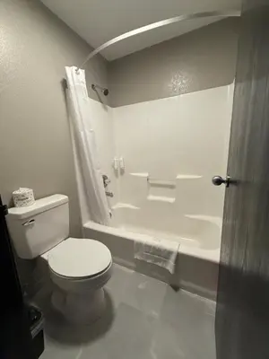 a bathroom with a toilet and a bath tub at Super 8 by Wyndham Richfield Cleveland in Richfield