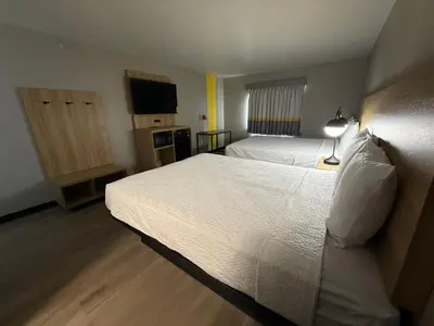 a hotel room with two beds and a television at Super 8 by Wyndham Richfield Cleveland in Richfield