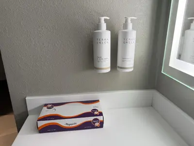 two bottles of shampoo and a box on a shelf at Super 8 by Wyndham Richfield Cleveland in Richfield