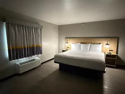 a hotel room with a bed and two lamps and a window at Super 8 by Wyndham Richfield Cleveland in Richfield