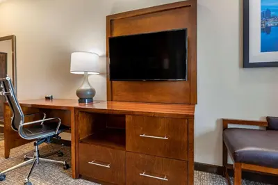 a room with a desk with a television and a chair at Comfort Suites Columbus Airport in Columbus