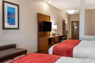 a hotel room with two beds and a flat screen tv at Comfort Suites Columbus Airport in Columbus