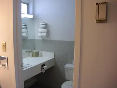 a bathroom with a sink and a toilet and a mirror at Kings Inn Cleveland in Strongsville