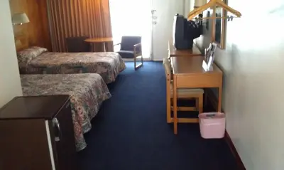 a hotel room with two beds and a desk at Kings Inn Cleveland in Strongsville