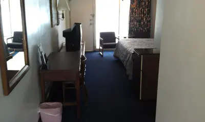 a hotel room with a bedroom with a bed and a desk at Kings Inn Cleveland in Strongsville