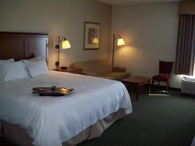 a hotel room with a bed with a tray on it at Hampton Inn Sidney in Sidney