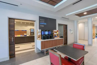 a waiting room with a table and chairs and a counter at Holiday Inn Express Hotel & Suites Richwood - Cincinnati South by IHG in Richwood