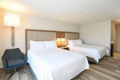 a hotel room with two beds and a chair at Holiday Inn Express Hotel & Suites Richwood - Cincinnati South by IHG in Richwood