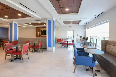 a dining room with tables and chairs and a couch at Holiday Inn Express Hotel & Suites Richwood - Cincinnati South by IHG in Richwood