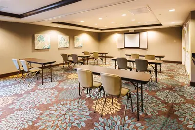 a conference room with tables and chairs on a carpet at Staybridge Suites Toledo/Maumee by IHG in Maumee