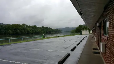 a parking lot next to a body of water at Budget Host Inn Charleston in Charleston