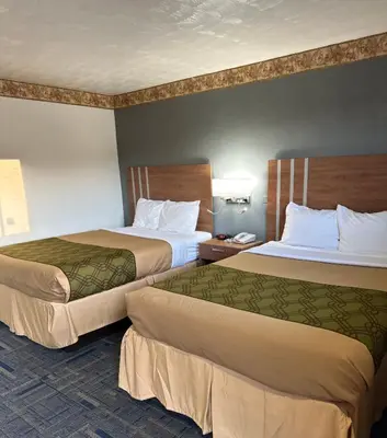 a hotel room with two beds and a phone at Budget Host Inn Charleston in Charleston